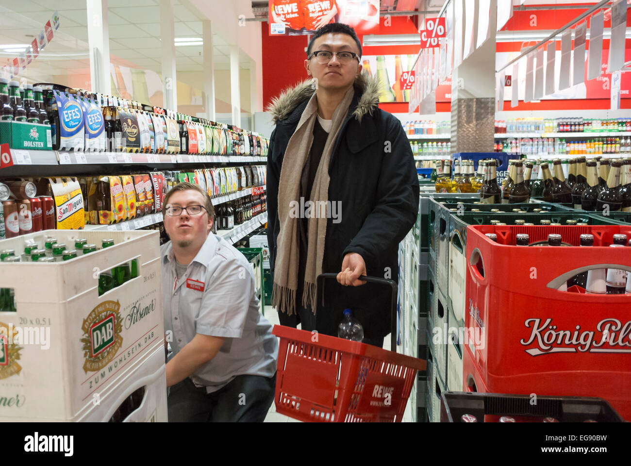 Berlin, Deutschland, Chinese man Shopping in deutschem Supermarkt, „Rewe“ Tragen Basket, Soda-Erfrischungsgetränke, Holding Basket, (Asian man is Model Release) Innenansicht des Supermarktes, chinesische Käuferinnen und Käufer verarbeiteten Lebensmitteln Stockfoto