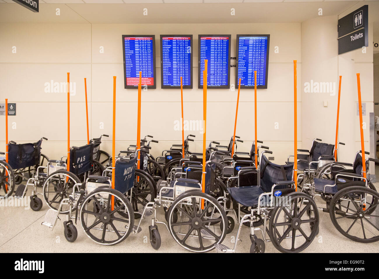 Chicago, Illinois - Rollstühle gespeichert unter Bildschirme, die Ankünfte und Abflüge am Flughafen Midway. Stockfoto