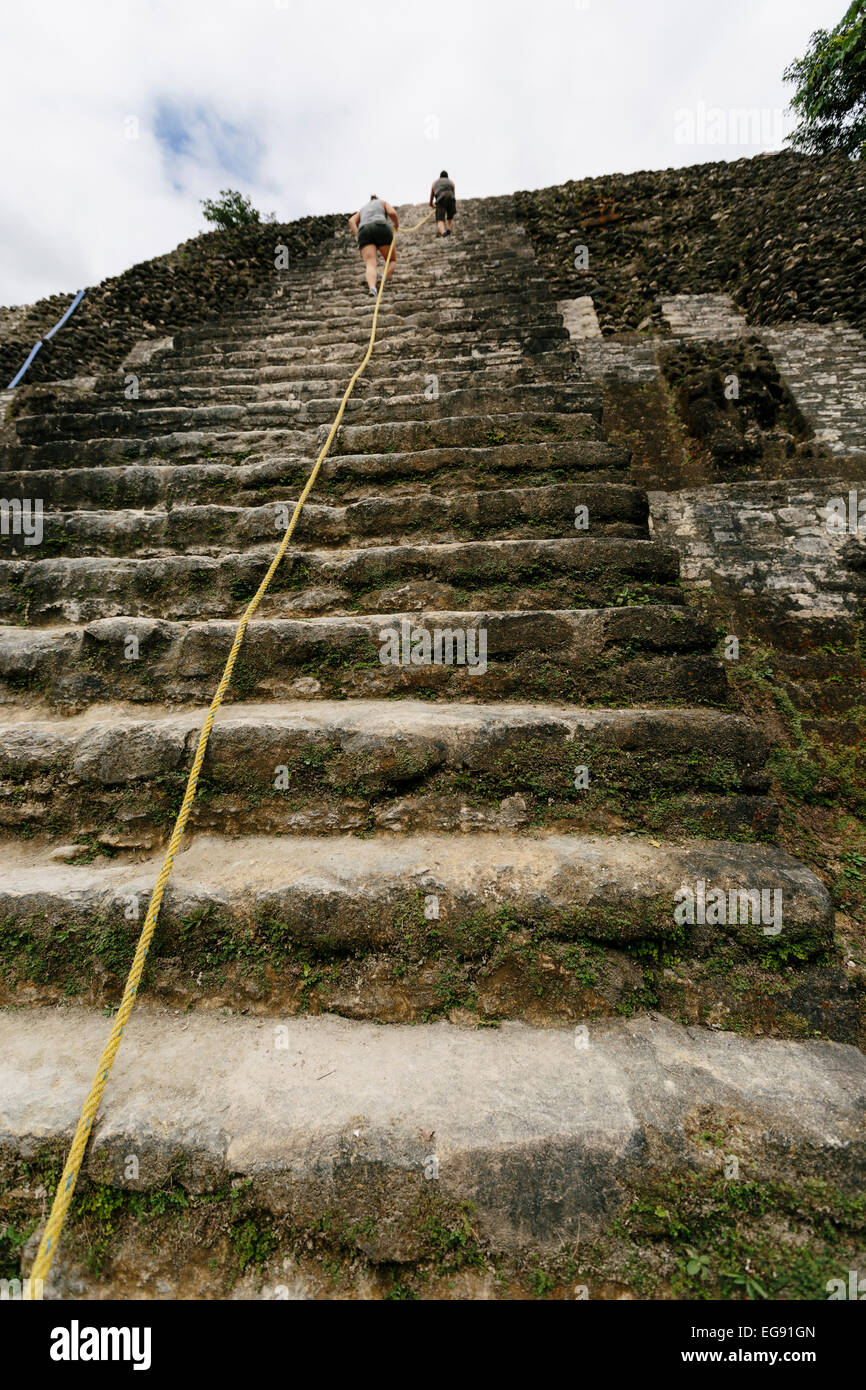 Es ist A langer Weg bis die Treppen - zwei Touristen die steilen Treppen in einem Tempel in Lamanai, Belize (Hochformat) Stockfoto