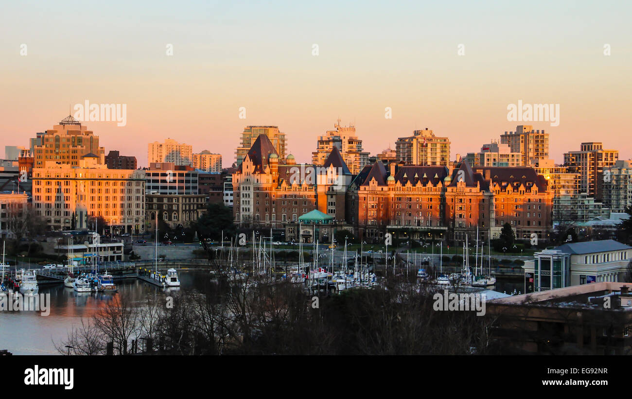 Sonnenuntergang über die Gebäude der Innenstadt von Victoria über Boote im Hafen. Stockfoto