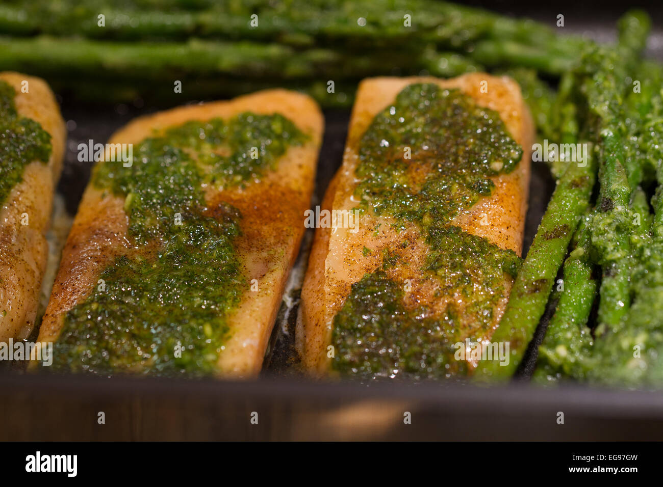 Gebackener Lachs mit Spargel und Paprika beschichtet mit Petersilie und Knoblauch Stockfoto