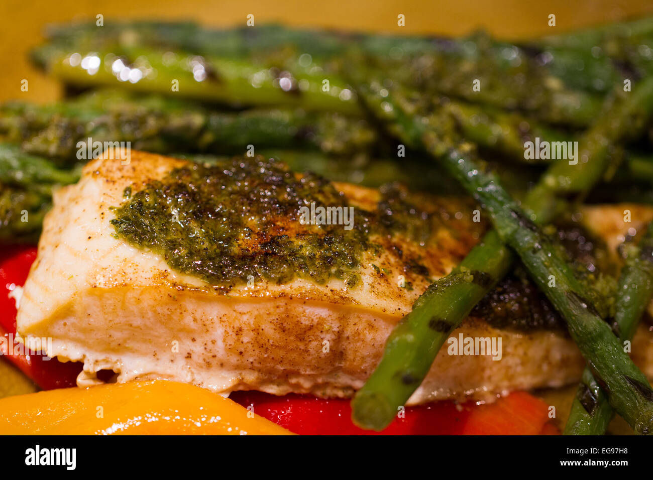 Gebackener Lachs mit Spargel und Paprika beschichtet mit Petersilie und Knoblauch Stockfoto