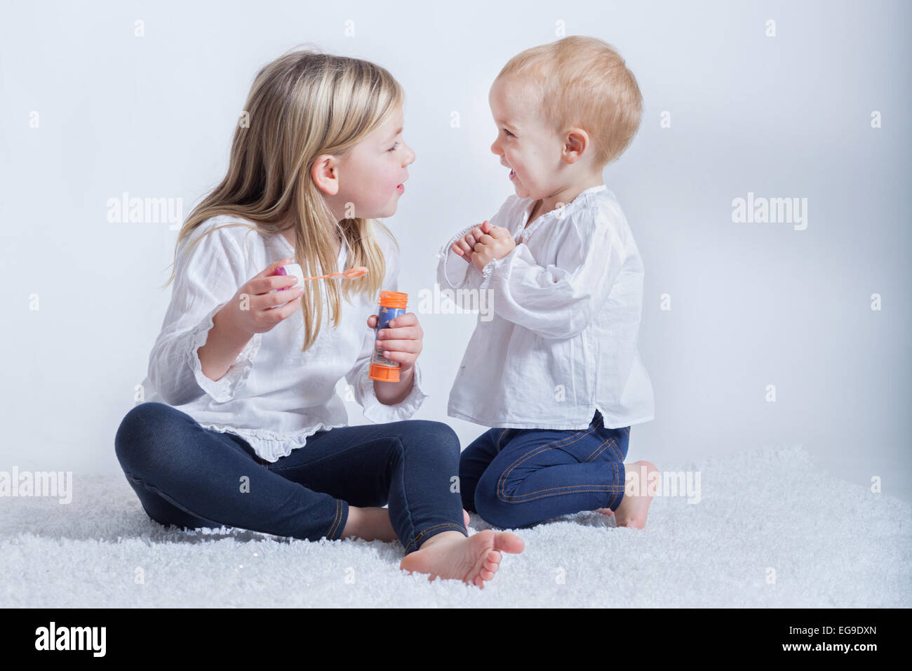 Zwei Kinder spielen mit einem Blasenstab Stockfoto