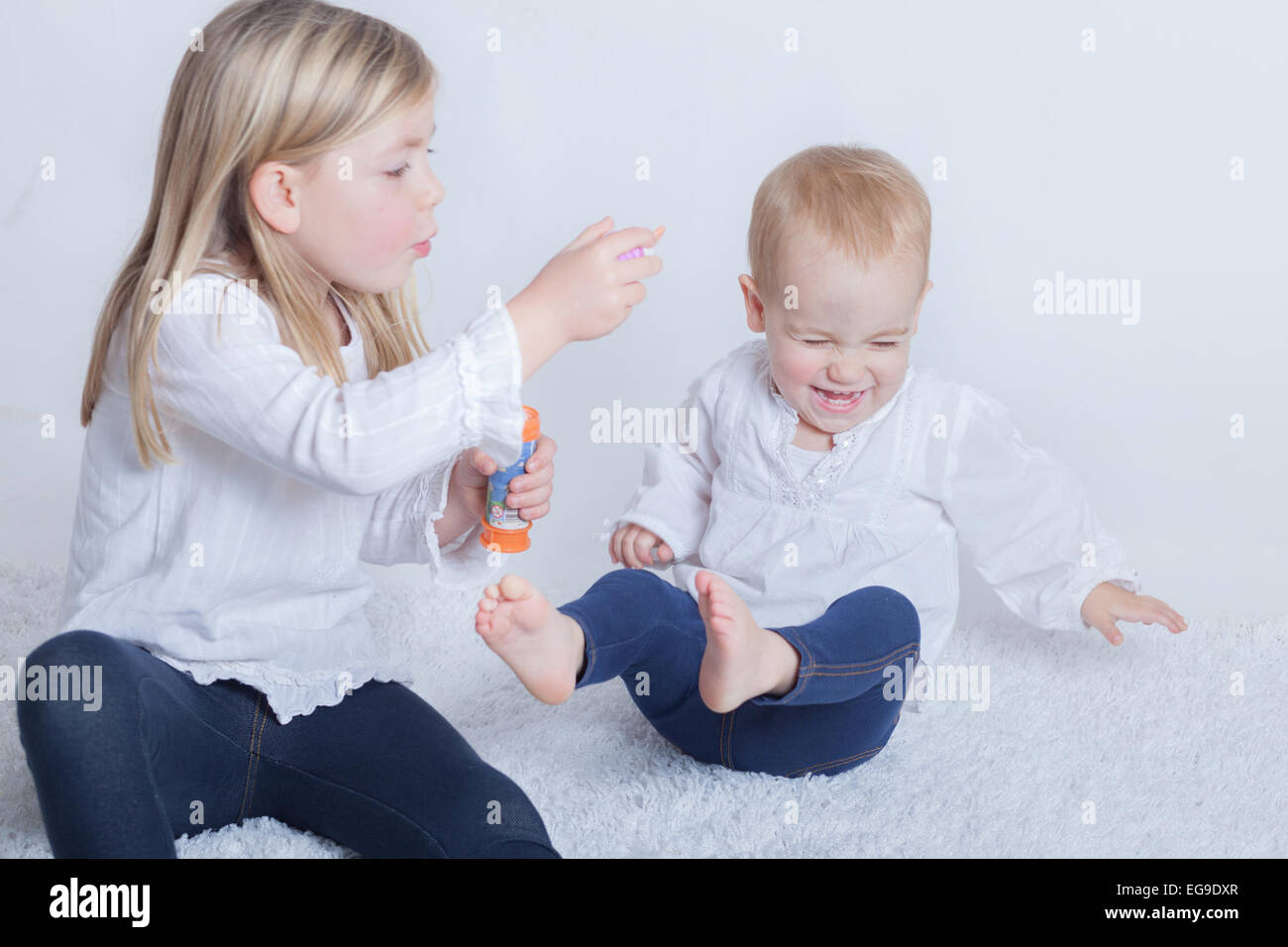 Zwei Kinder spielen mit einem Blasenstab Stockfoto