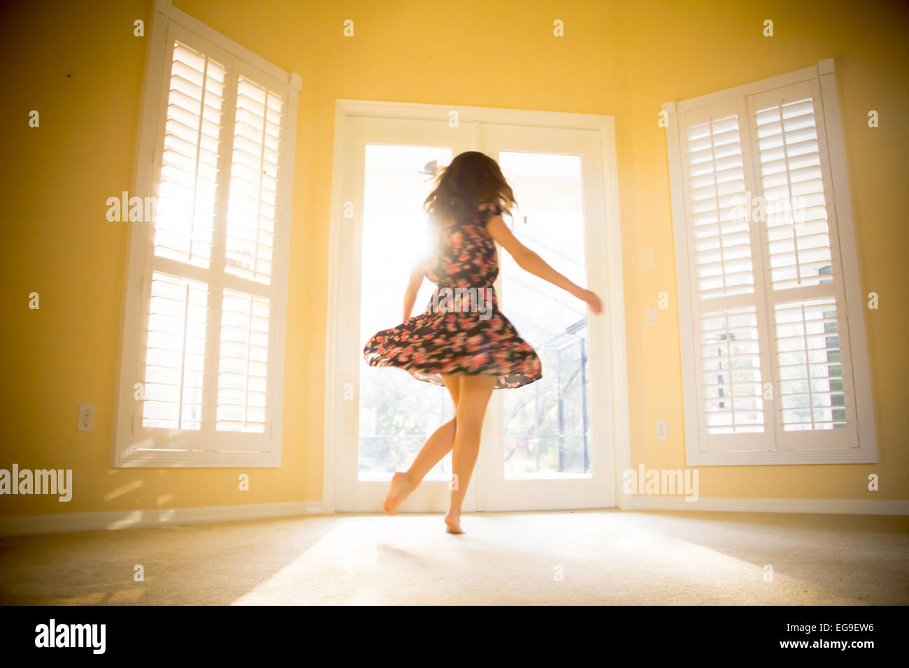 Junge Frau, die Spinnerei in sonniges Zimmer Stockfoto