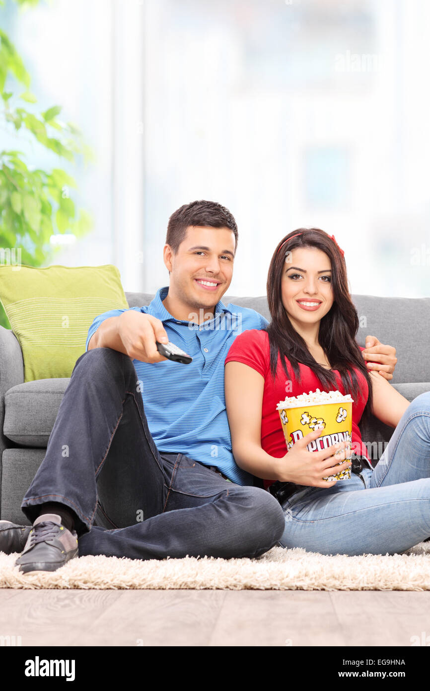 Vertikale Schuss ein glückliches Paar vor dem Fernseher und Essen Popcorn zu Hause Stockfoto
