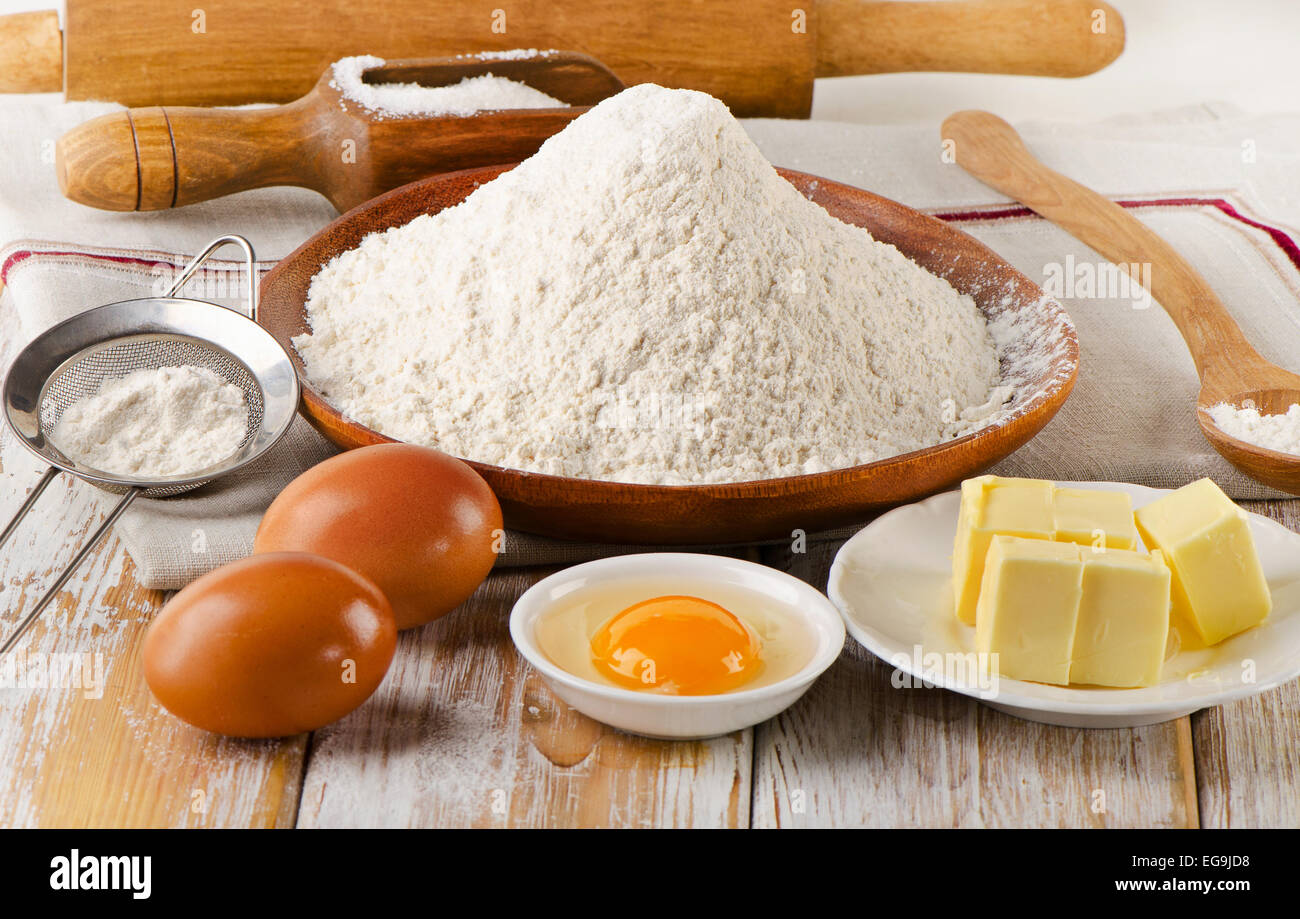 Backzutaten - Eiern, Mehl, Zucker, butter auf weißem Holz Hintergrund ...