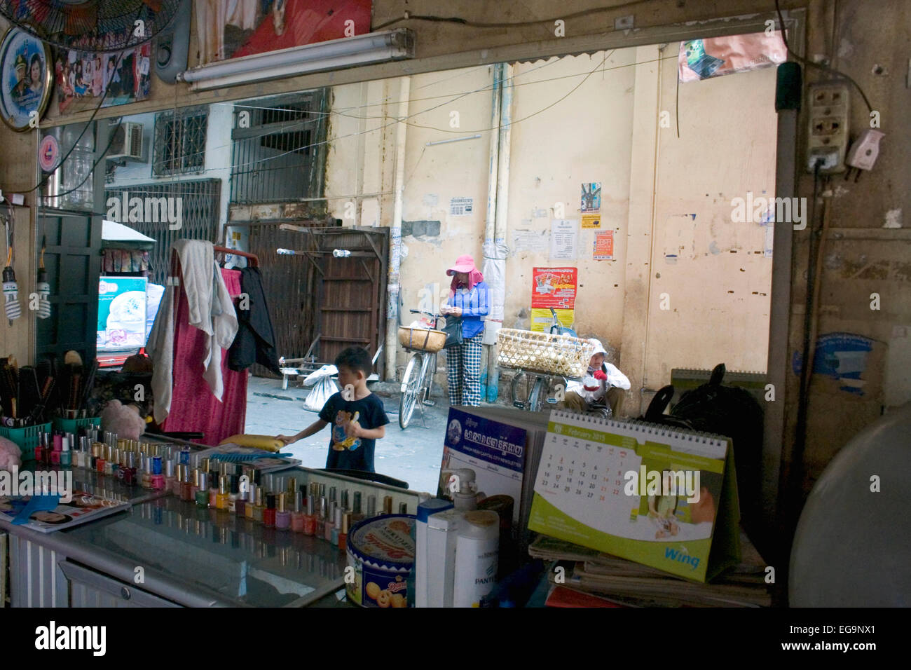 Ein Spiegel in einem Schönheitssalon reflektiert Streetfood Verkäufer ruht in einer Gasse in Penh, Kambodscha. Stockfoto