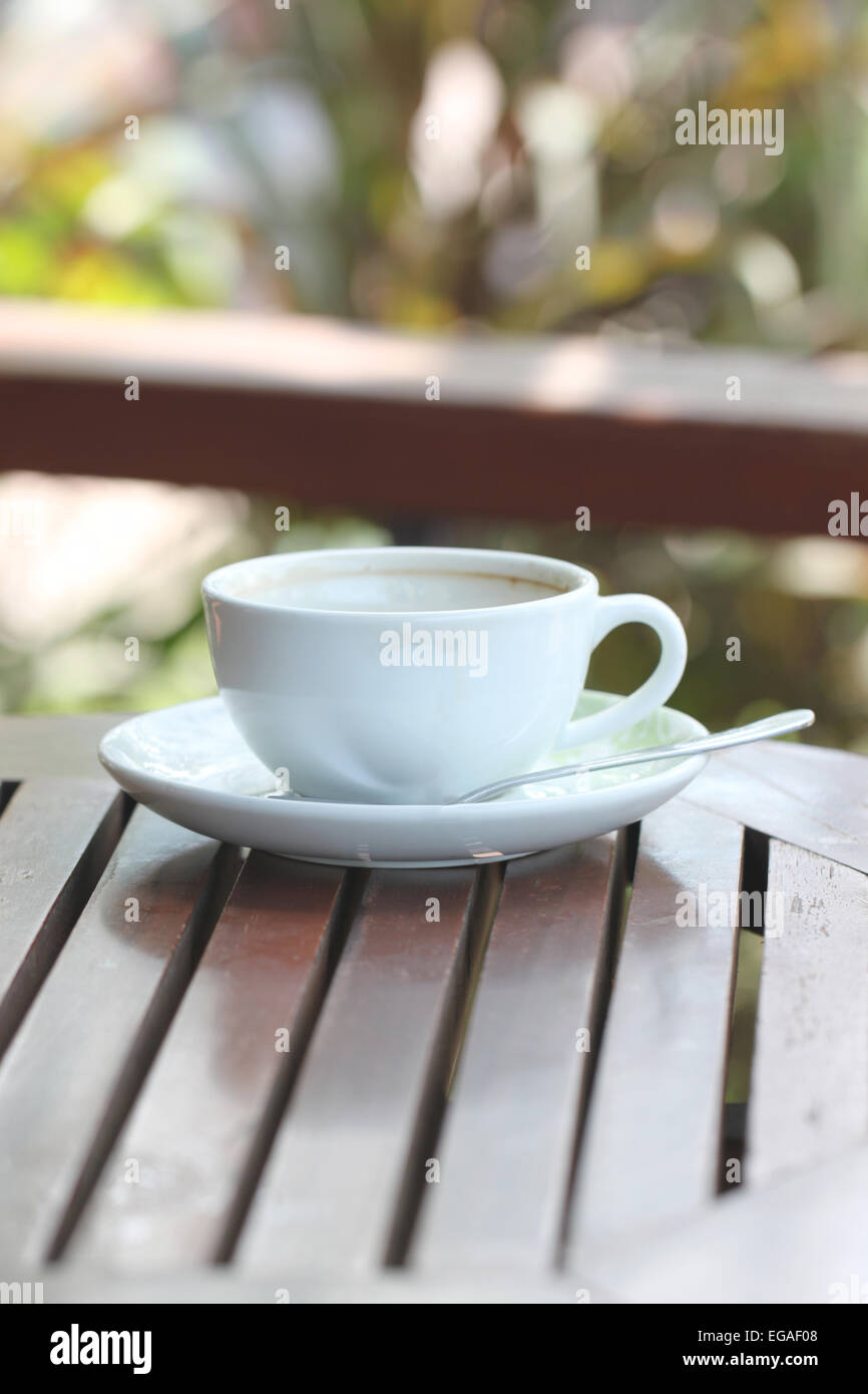 Weiße Kaffeetasse auf braunen Holztisch. Stockfoto