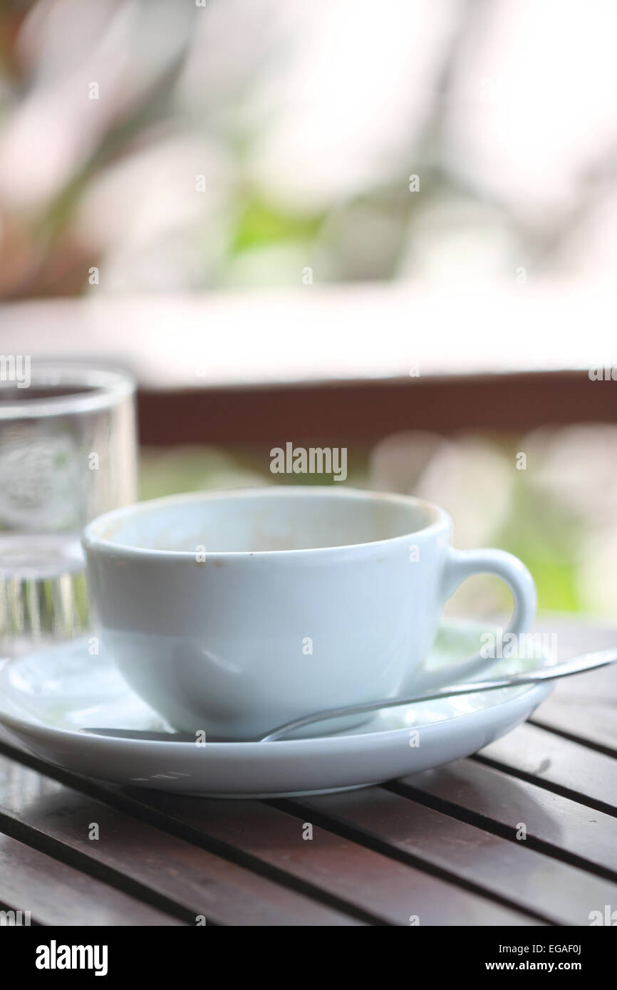 Weiße Kaffeetasse auf braunen Holztisch. Stockfoto