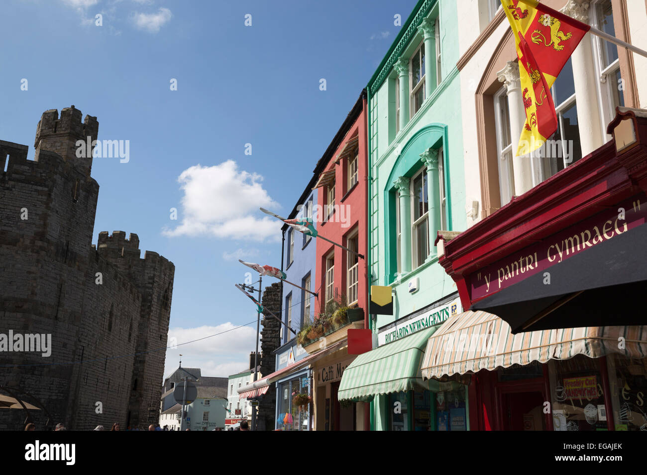 Ladenfronten unter Caernarfon Castle, Schlossplatz, Caernarfon, Snowdonia, Gwynedd, Wales, Vereinigtes Königreich, Europa Stockfoto