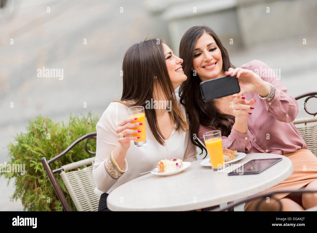 Junge Frauen, die Fotos mit dem Handy im café Stockfoto