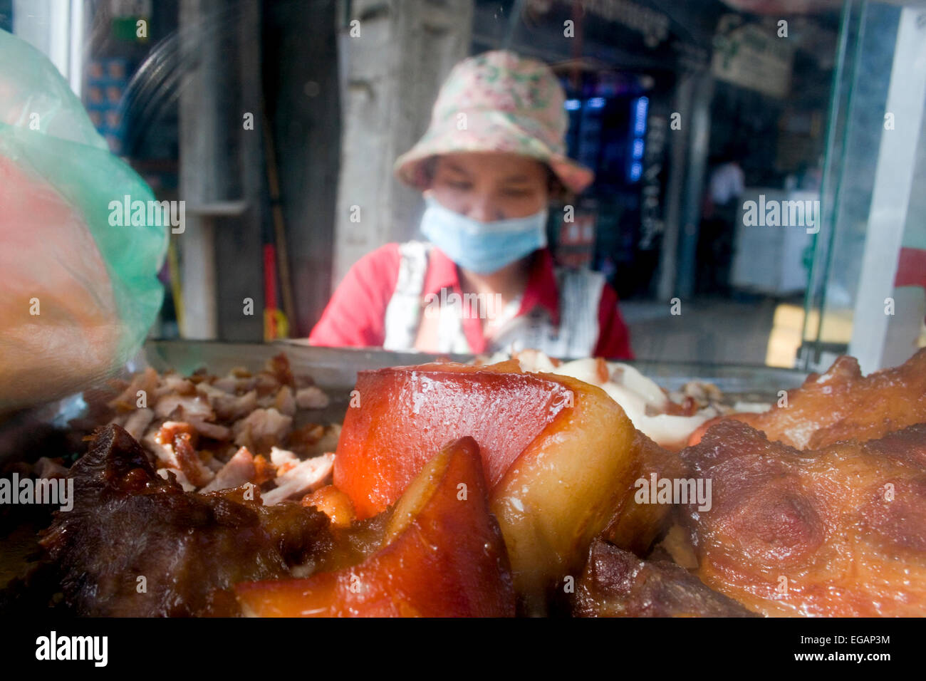 Eine Frau macht Schinkensemmeln, die sie als Straße Nahrung von einem mobilen Lebensmittel Karren auf eine Stadt in Kampong Cham, Kambodscha Straße verkauft. Stockfoto