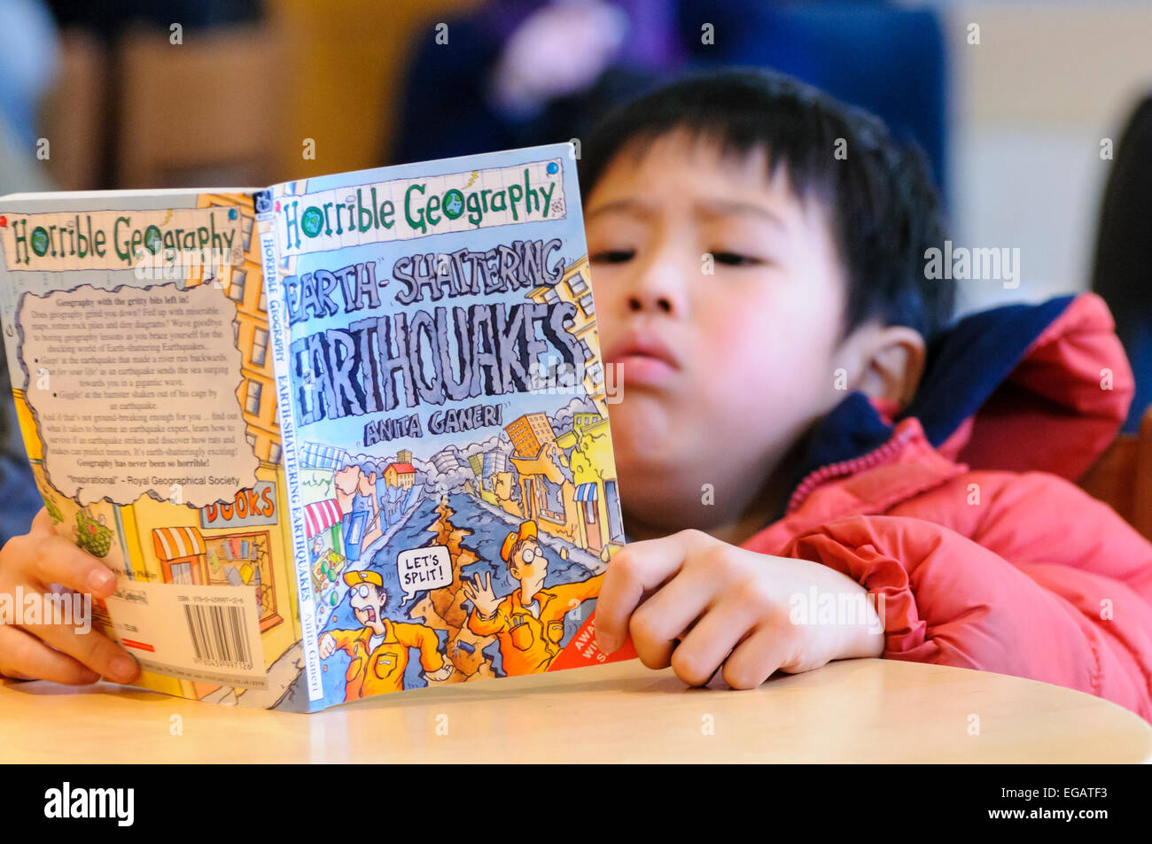 Eine junge japanische Junge liest ein Buch über Erdbeben wenige Tage nach der Katastrophe von Fukushima Stockfoto