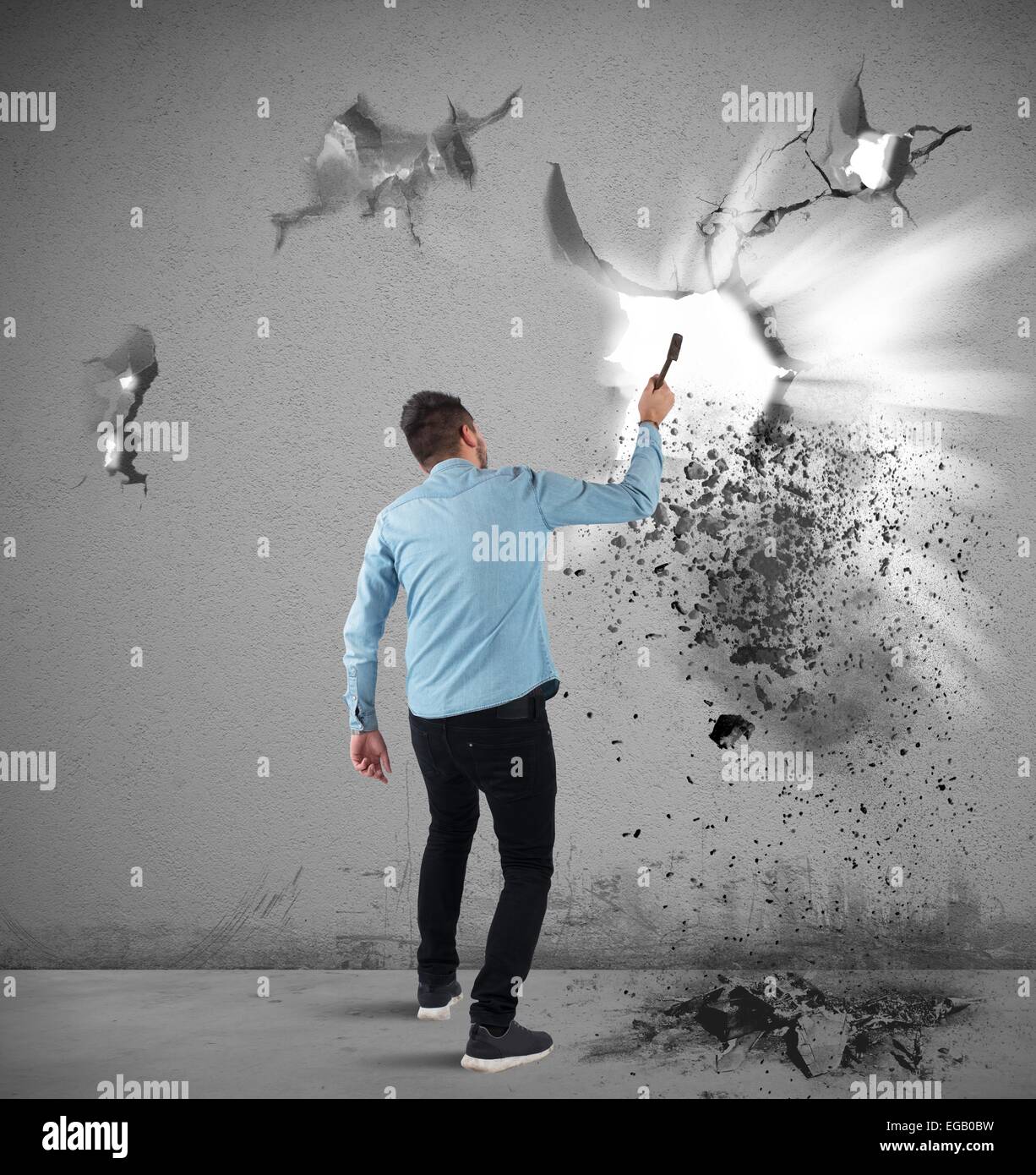 Mann bricht eine Wand Stockfoto