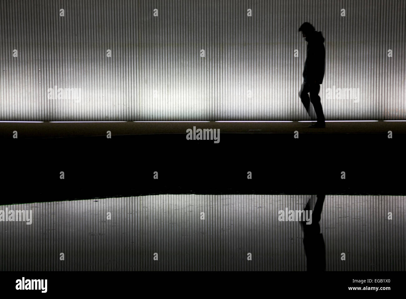 Einsamer Mann zu Fuß unter einer Brücke/tunnel Stockfoto