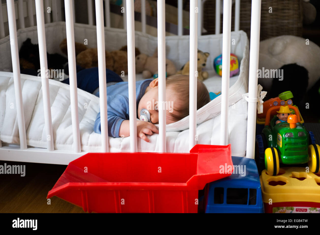 Baby schläft im Laufstall Stockfoto