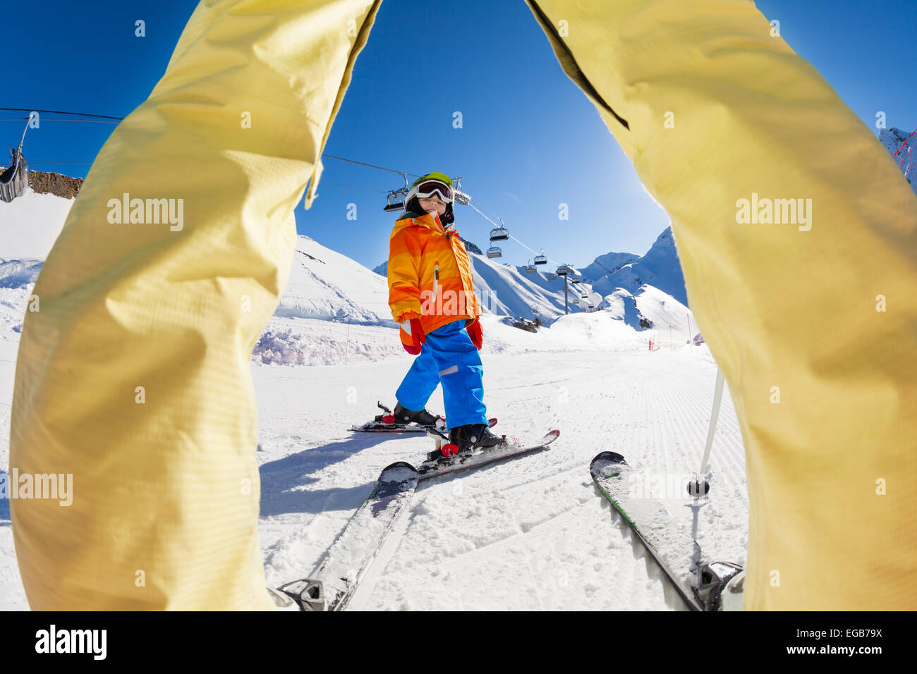 Ski junge Blick zwischen die Beine der Erwachsenen Stockfoto