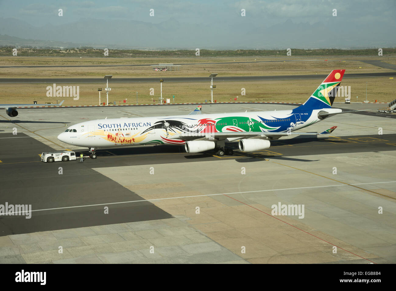 SAA A340 Jet mit Schlepper in Anwesenheit des Flugzeugs ist im Olympia-Logo gemalt. Stockfoto