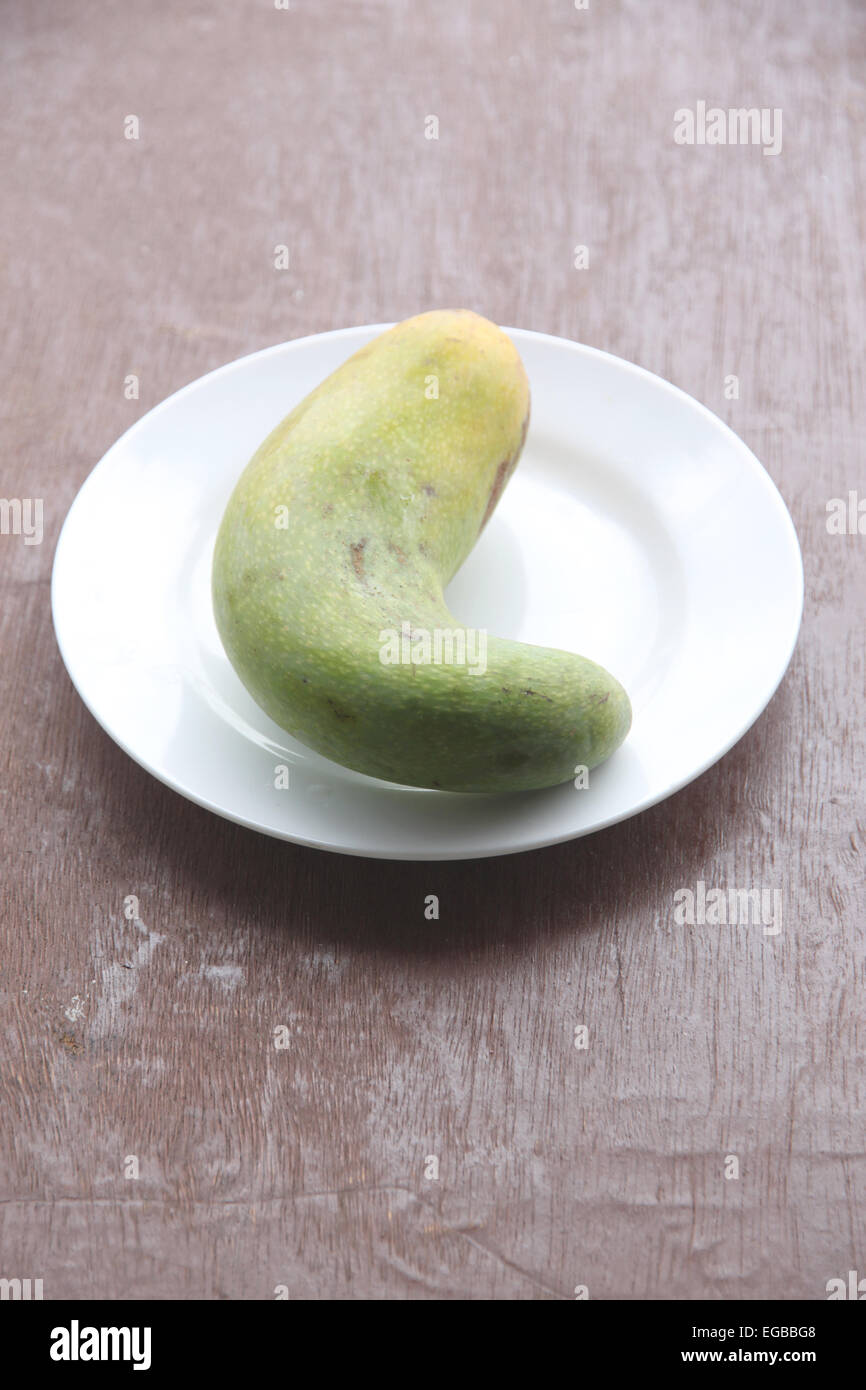 Frische Mango-Frucht in Schale auf der Lebensmittel-Tabelle. Stockfoto