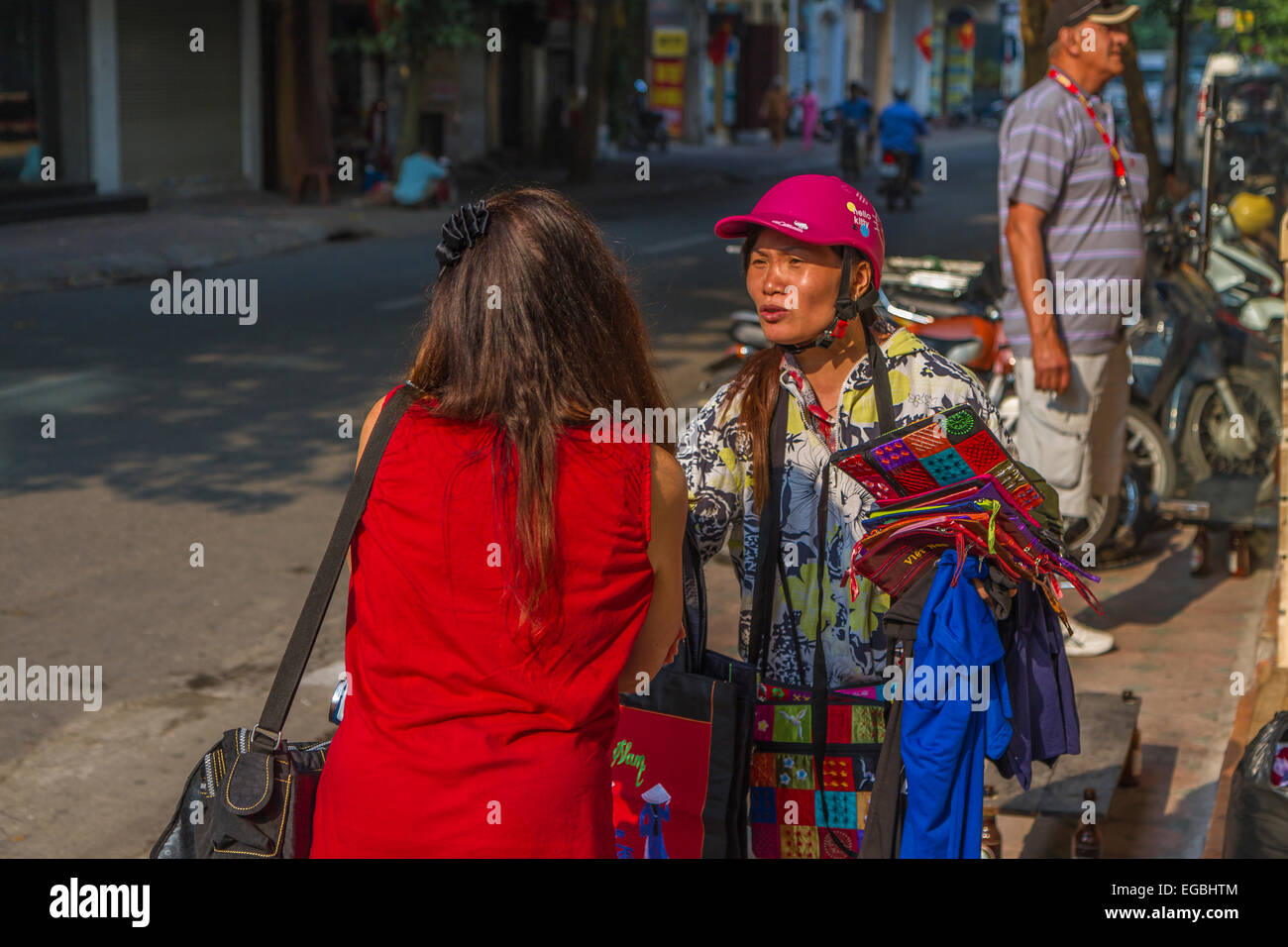 Ehrgeizige Straße Verkäufer versuchen, ihre waren zu einem touristischen in Hanoi zu verkaufen Stockfoto