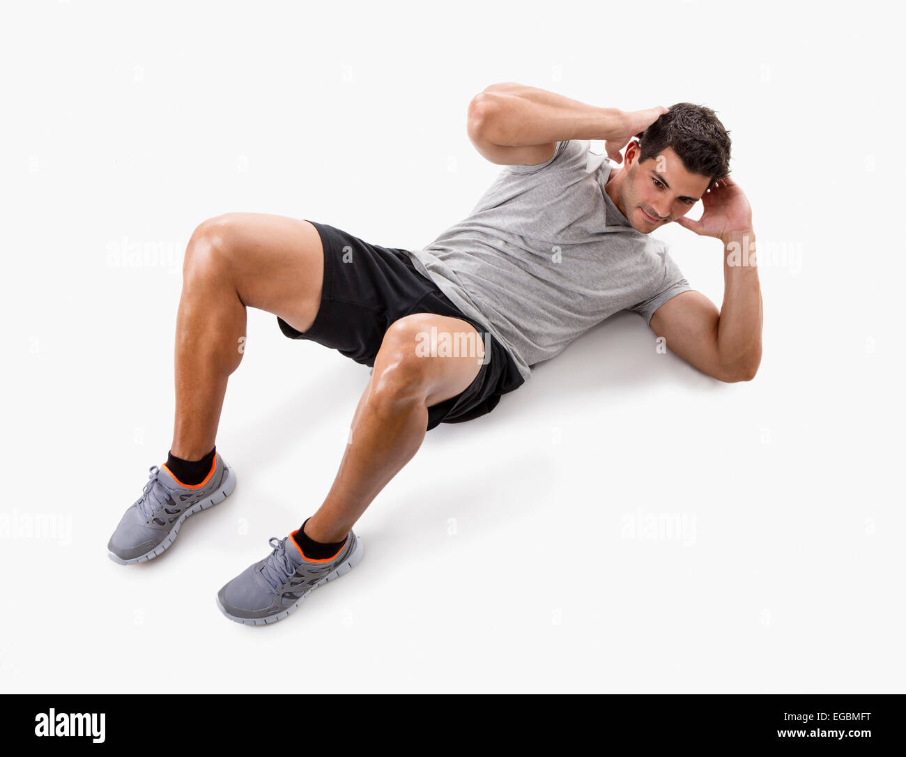 Sportlicher Mann Bauchmuskeln isoliert auf einem weißen Hintergrund zu tun Stockfoto