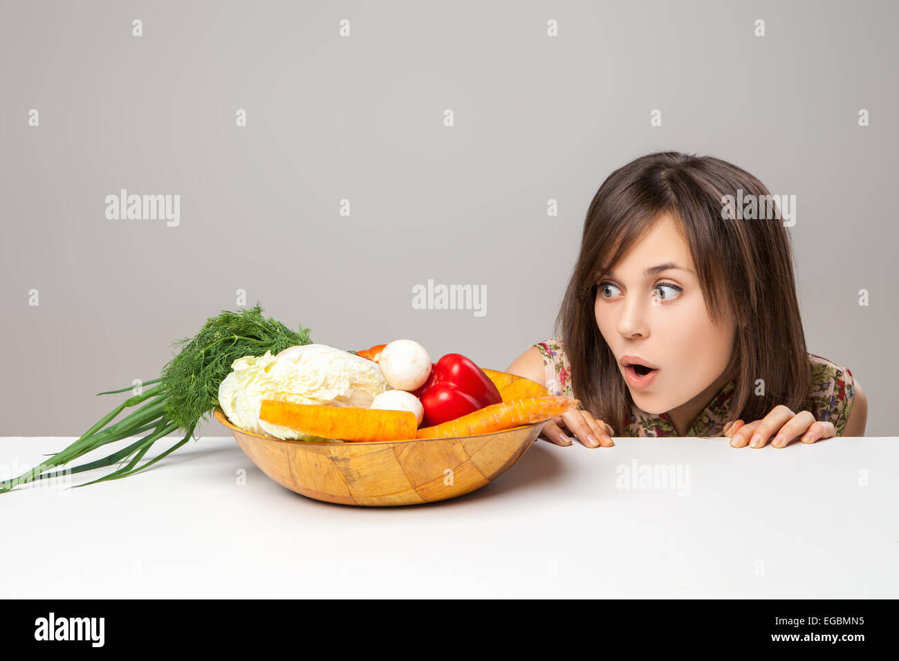 Frau mit grünem veganes Essen. Emotion zu überraschen. Stockfoto