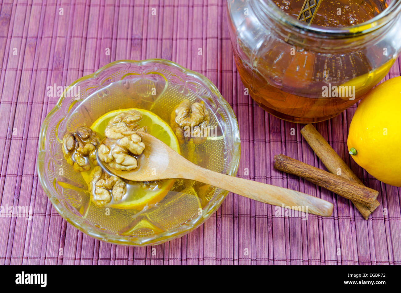 Walnüsse, Honig und Zimt in einem Glas auf einem Holztisch Stockfoto
