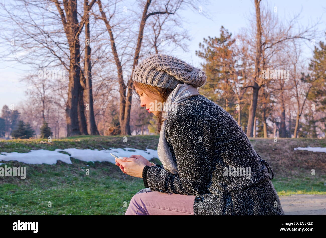 Junge Frau im freien SMS im winter Stockfoto