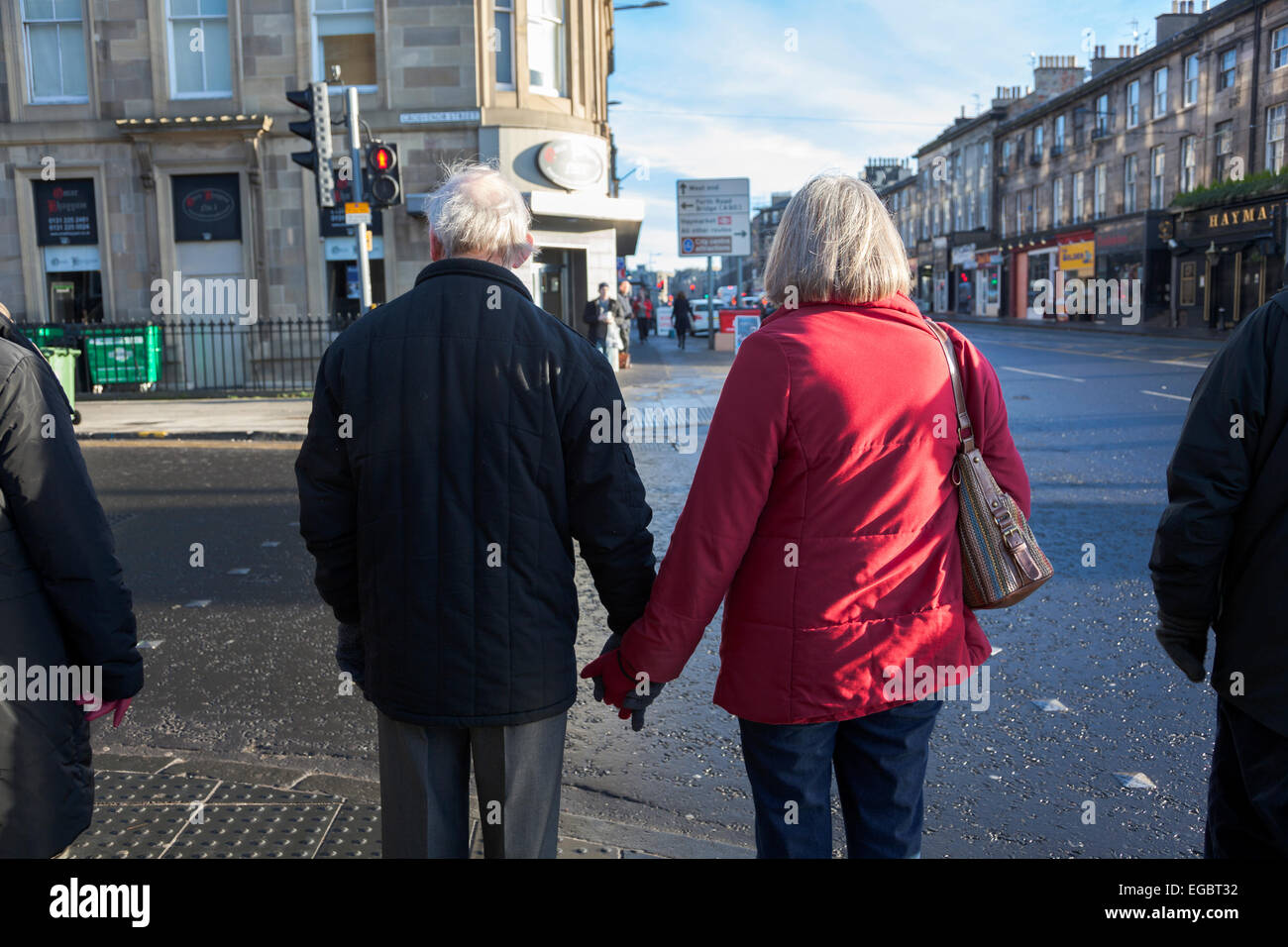 Ältere Paare Hand in Hand auf den Straßen von Edinburgh Stockfoto