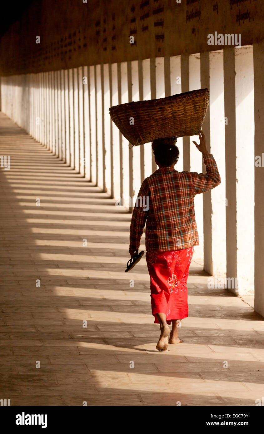 Eine burmesische Frau trägt einen Korb auf dem Kopf zu Fuß, von hinten, Bagan, Myanmar (Burma), Asien Stockfoto