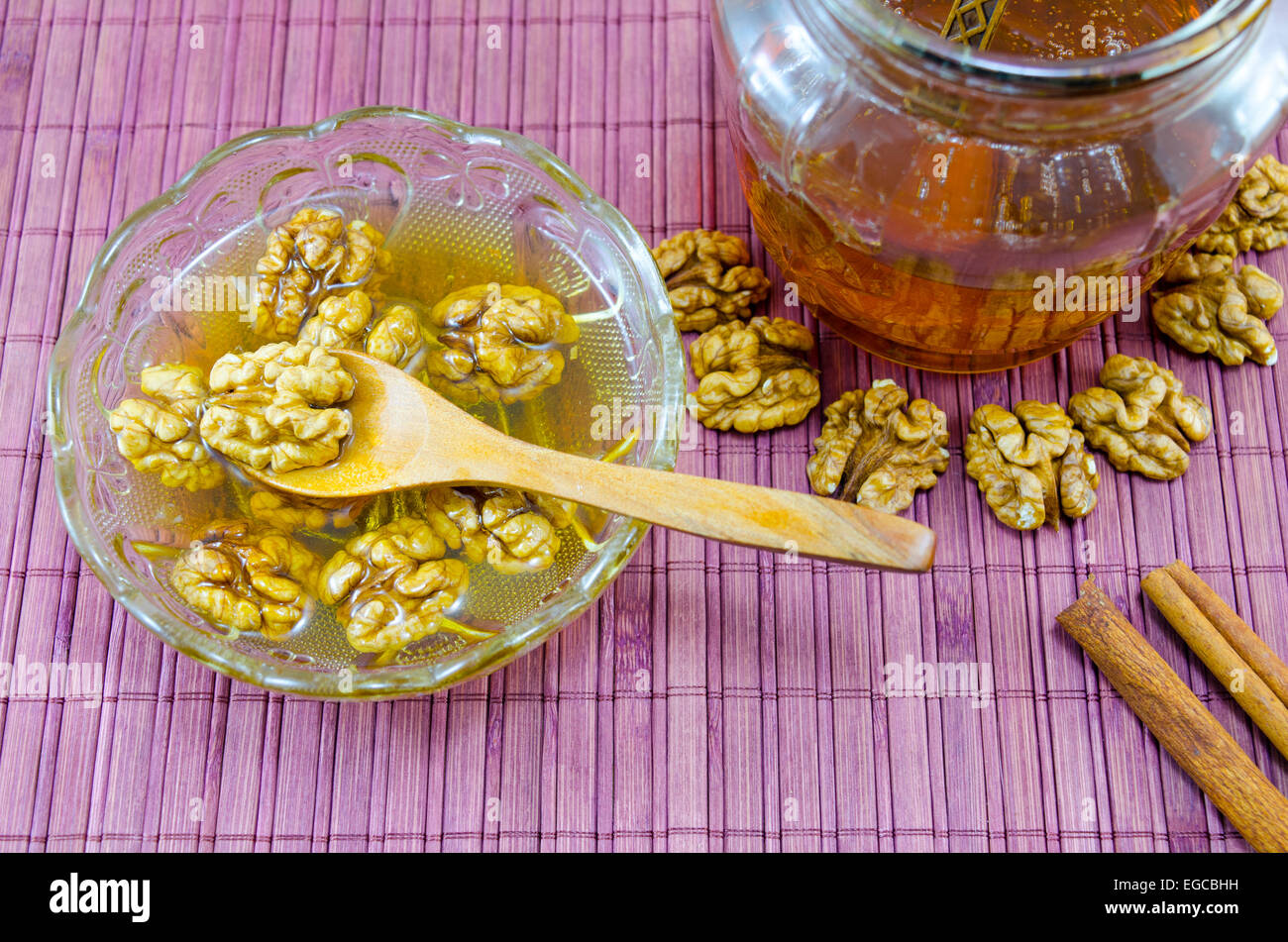 Walnüsse, Honig und Zimt in einem Glas auf einem Holztisch Stockfoto