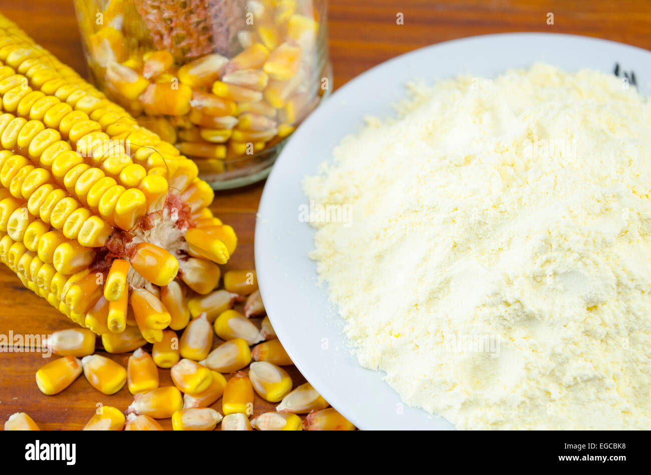 Ohr des Mais und einen Teller mit Mehl auf einem Holztisch Stockfoto