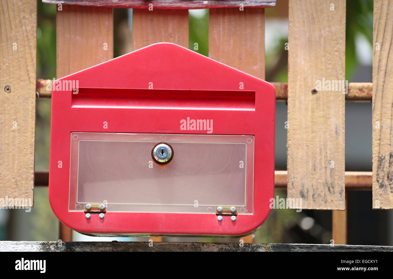 Roten Briefkasten an den Zaun gehängt. Stockfoto