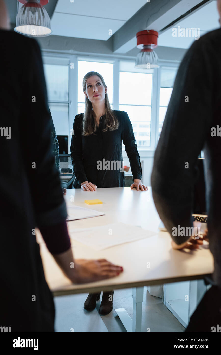 Junge weibliche Führungskraft mit Kollegen an einem Tisch im Büro. Geschäftsleute während der Sitzung. Stockfoto