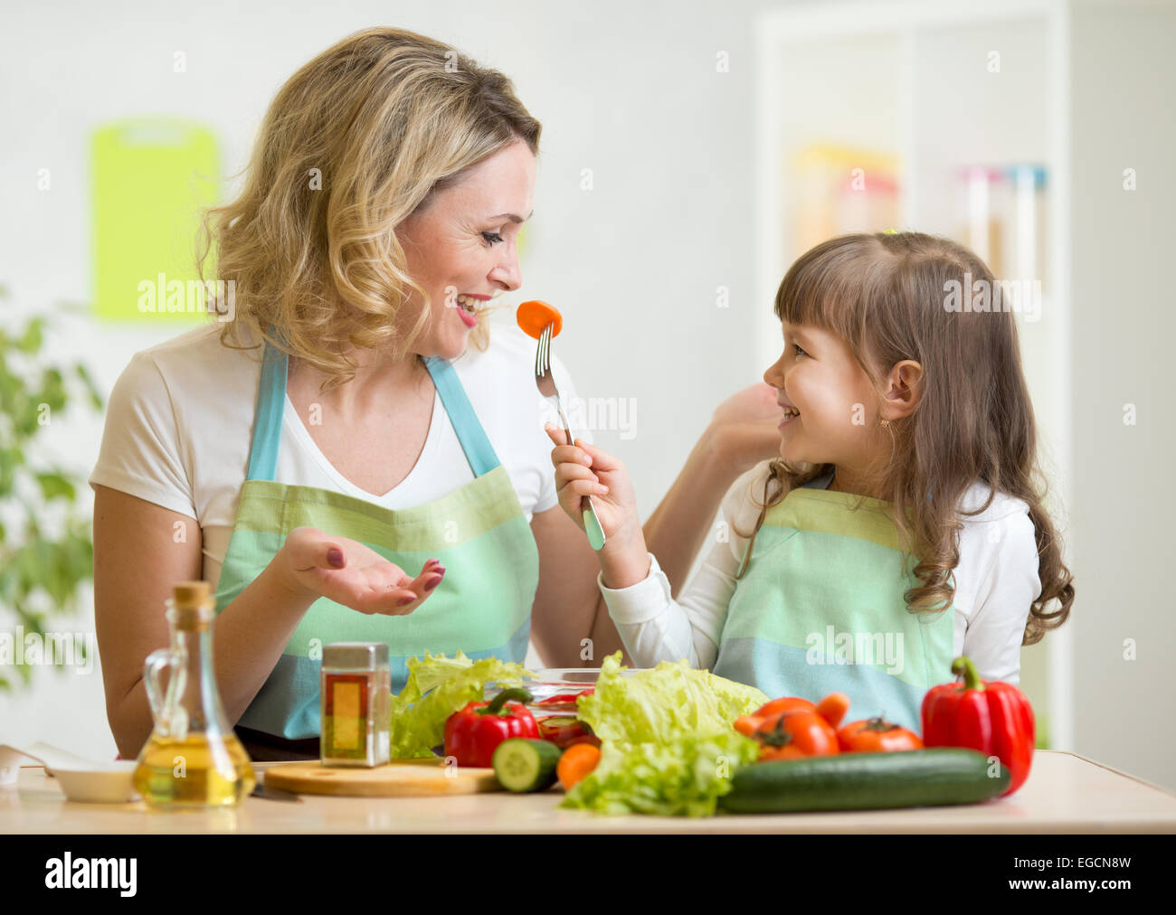 Kind Mädchen und Mutter essen gesundes Essen Gemüse Stockfoto