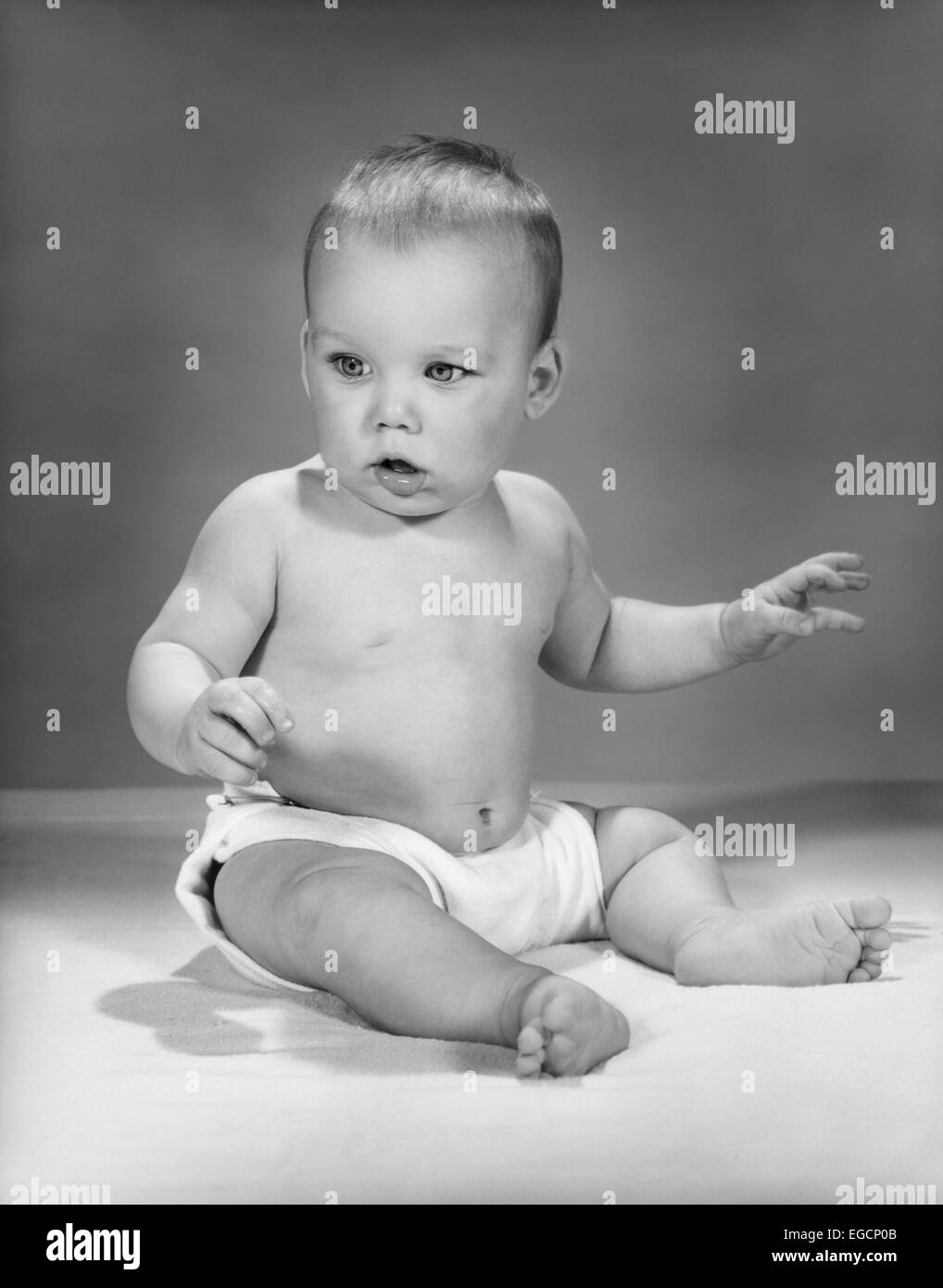 1960ER JAHRE BABY SITTING TRAGEN STOFFWINDEL Stockfoto