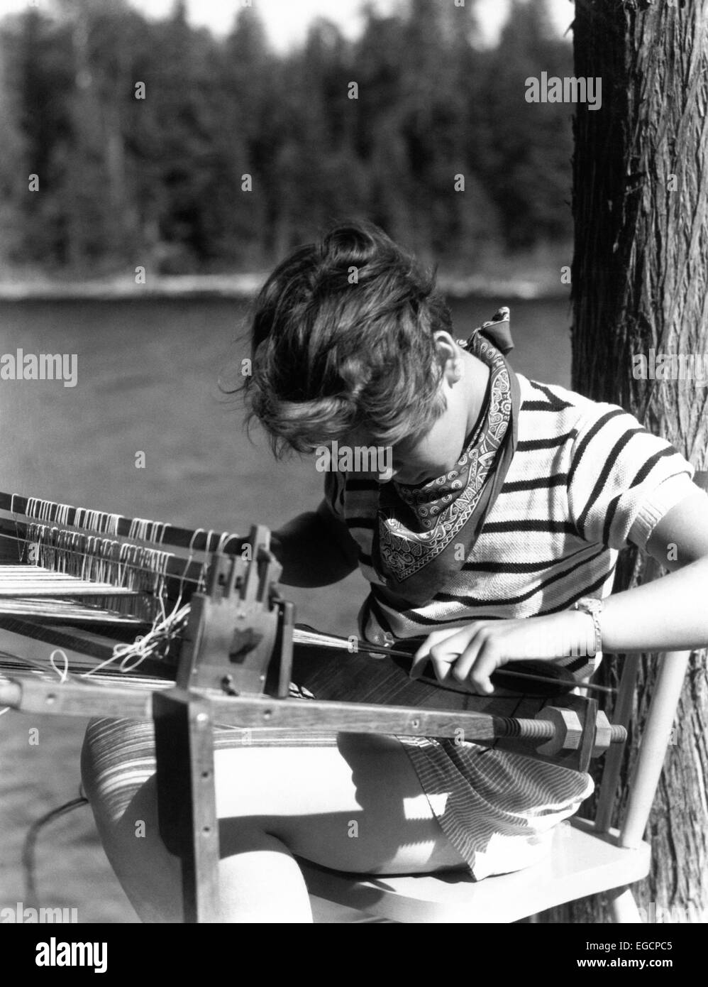 1930ER JAHREN MÄDCHEN AM SOMMERCAMP SEE LERNEN AUF CRAFT-PROJEKT WEBSTUHL ZU WEBEN Stockfoto