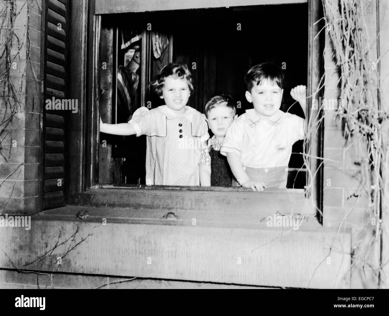 1930ER JAHREN ZWEI JUNGEN EIN MÄDCHEN AM OFFENEN FENSTER DES WAISENHAUSES HOMEWOOD SCHULE STEHEN UNVERHEIRATETE MÜTTER PHILADELPHIA Stockfoto