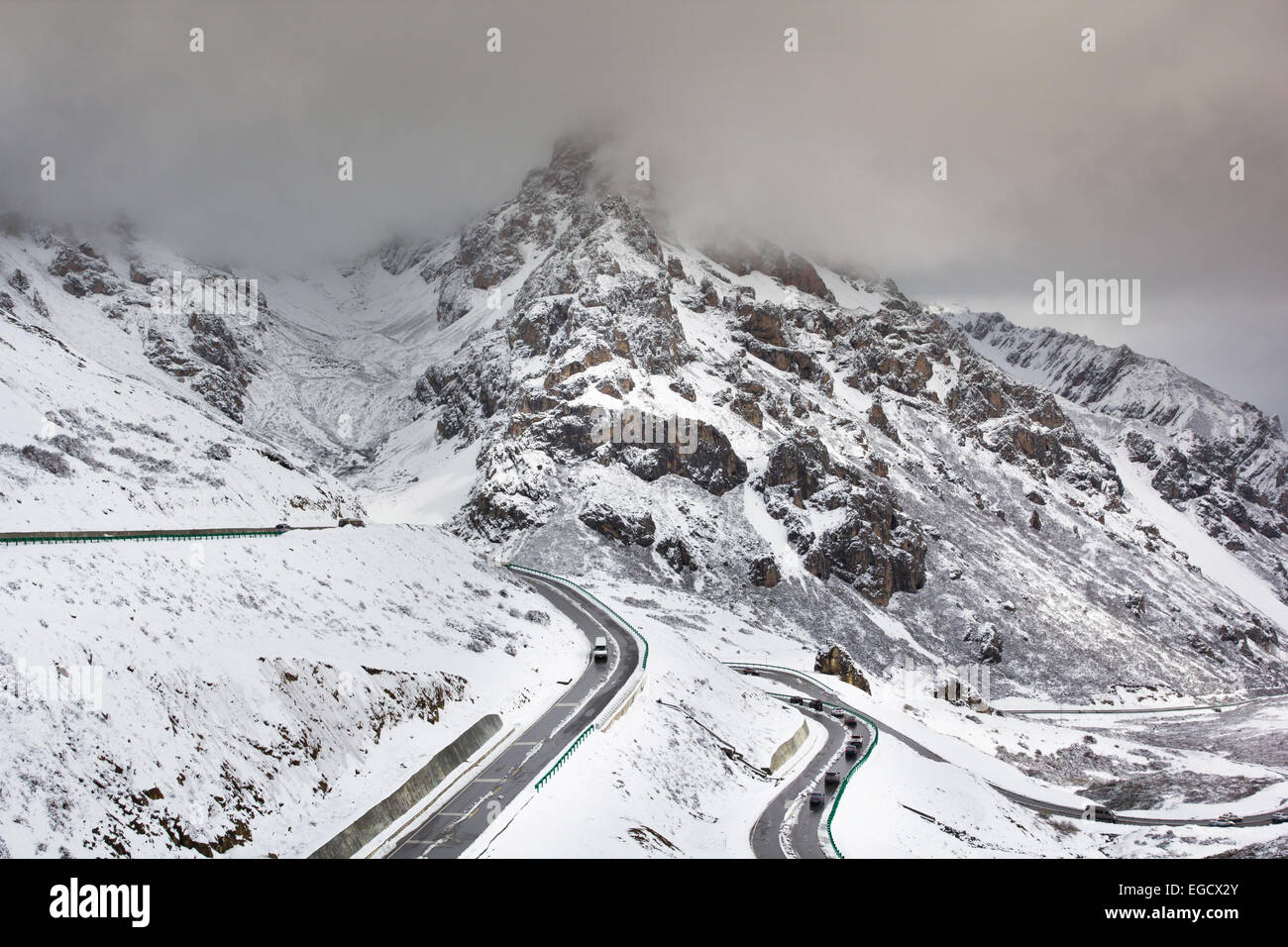 Straße für Reisen Kreuz Hochgebirge mit Schnee und Nebel Stockfoto