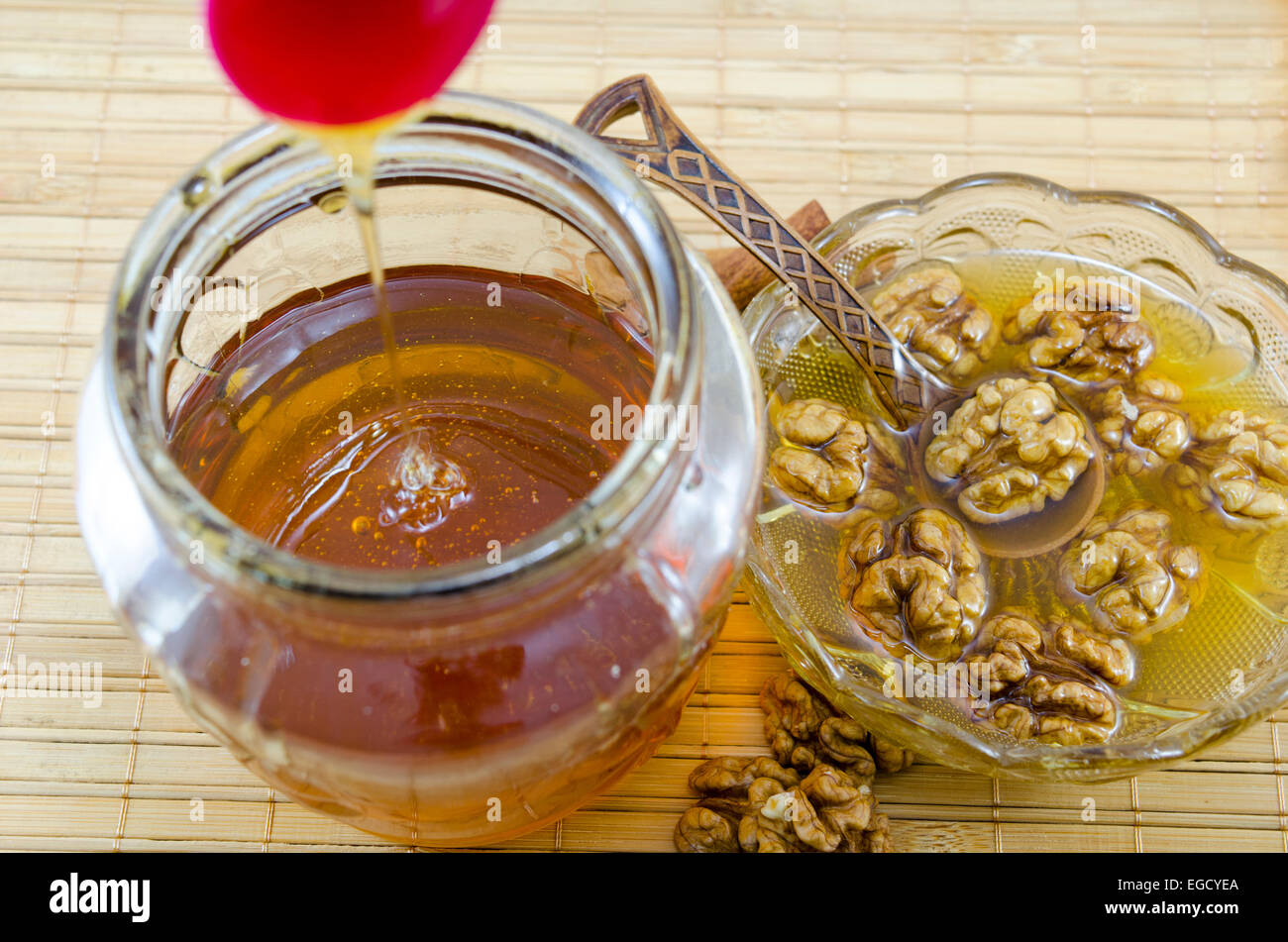 Walnüssen und Honig in einem Glas auf einem Holztisch Stockfoto