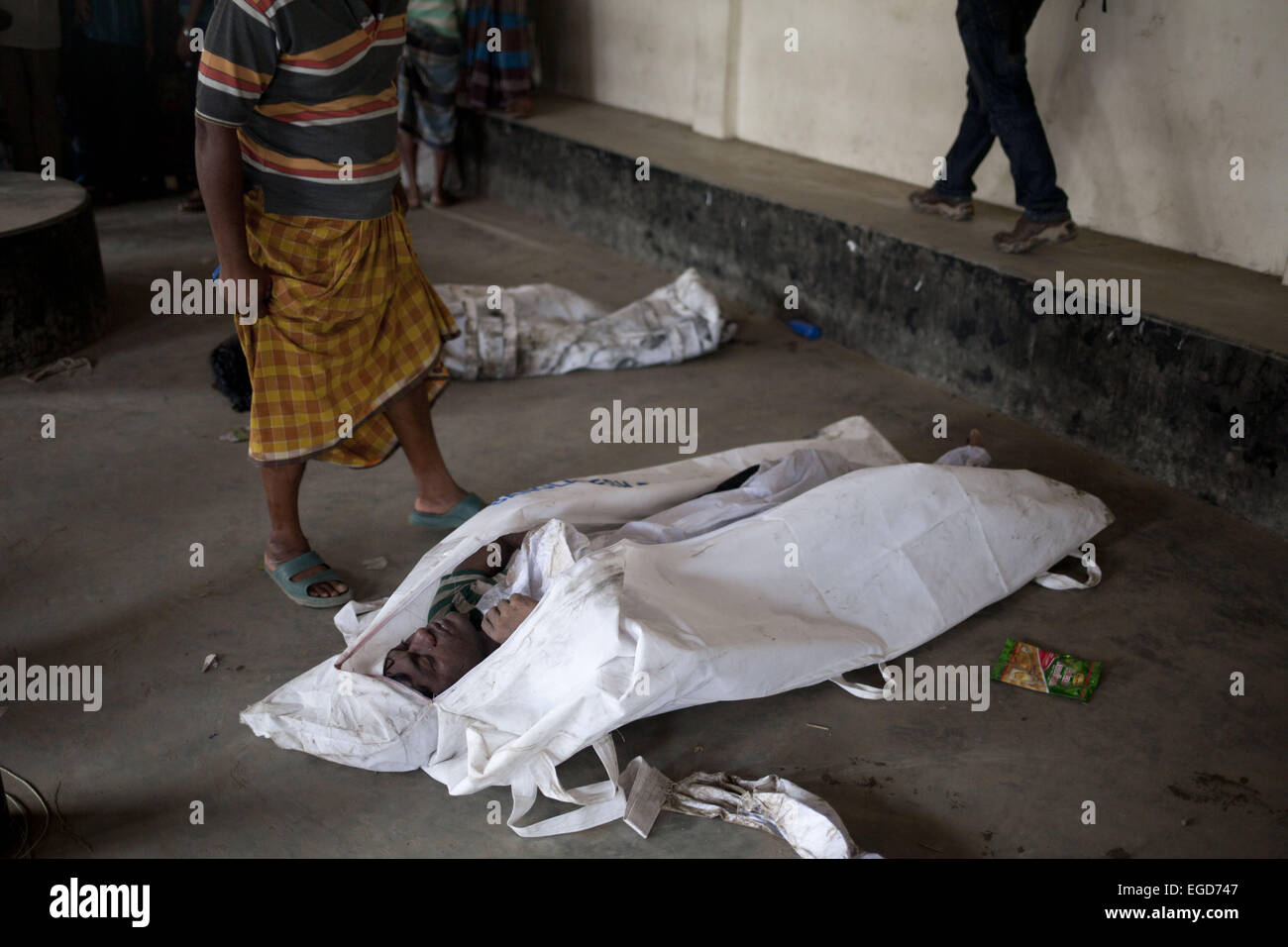 Manikgonj, Dhaka, Bangladesh. 23. Februar 2015. Bangladeshi Mann steht vor den Leichen geborgen von der Fähre, die in den Fluss Padma kenterte, nachdem er von einem Frachtschiff in Paturia, in Manikganj Bezirk, etwa 80 Kilometer nordwestlich von Dhaka, Bangladesh, Montag, 23. Februar 2015 getroffen. Bildnachweis: Suvra Kanti Das/ZUMA Wire/ZUMAPRESS.com/Alamy Live-Nachrichten Stockfoto