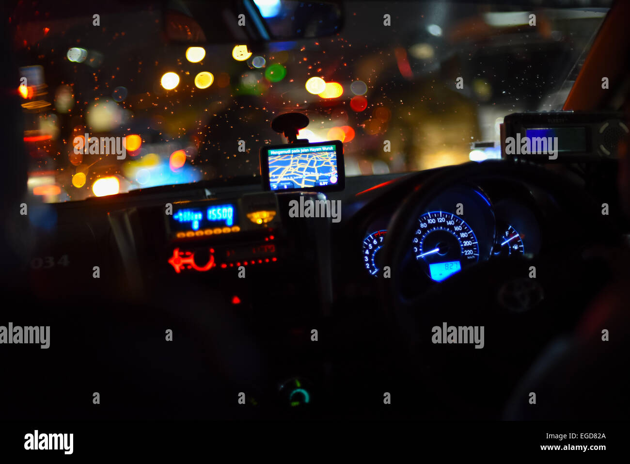 Armaturenbrett eines Taxis im Nachtverkehr, Jakarta. Stockfoto