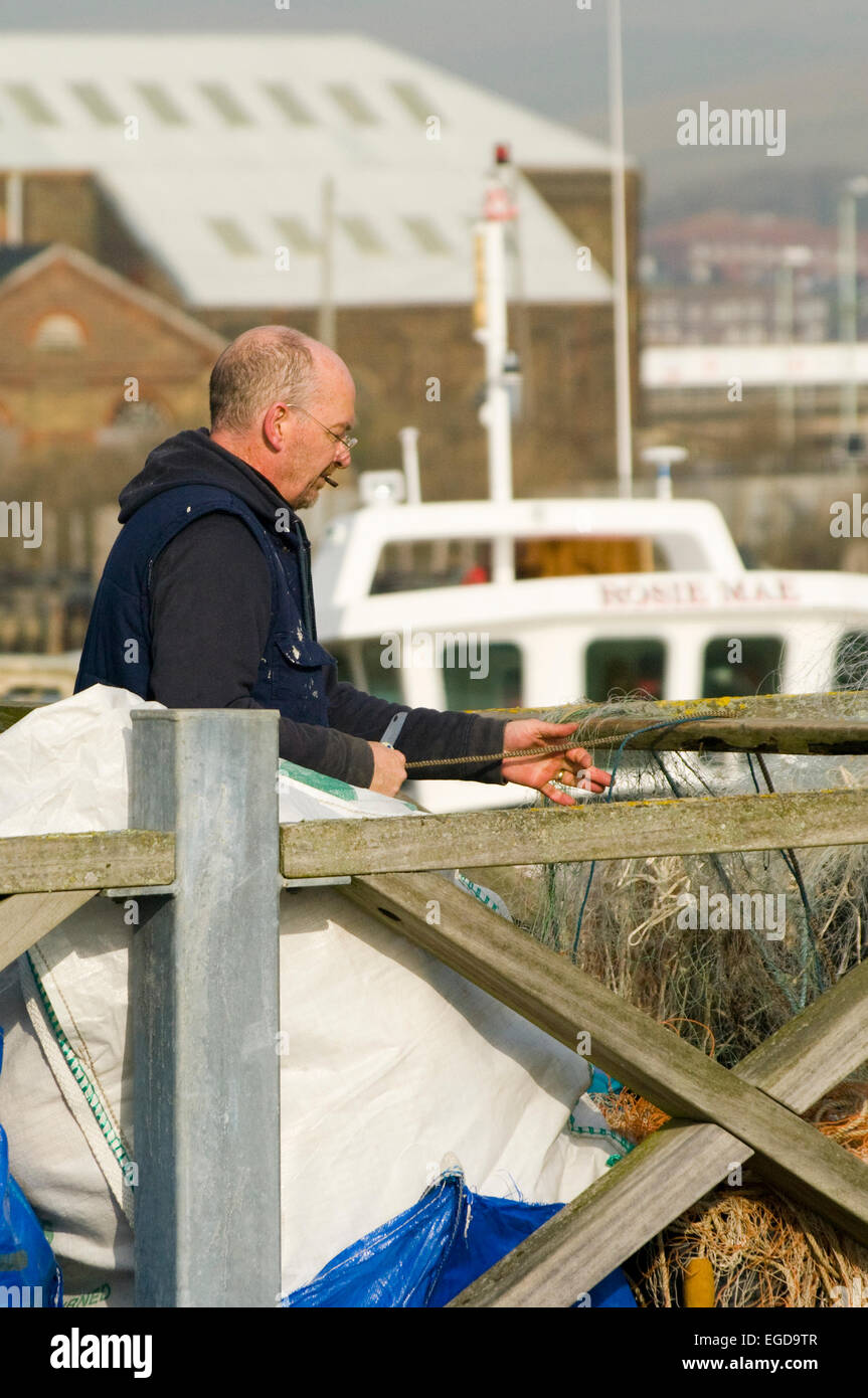 Berufsfischer Reparatur seine Netze auf einer Mole West Quay Newhaven East Sussex Stockfoto