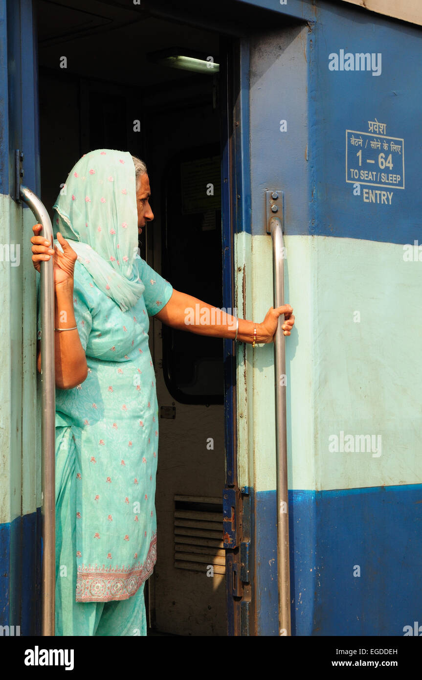 Eine ältere indische Frau trägt einen grünen Sari sieht aus der Tür eines Zuges Bahnhof Delhi Indien Stockfoto