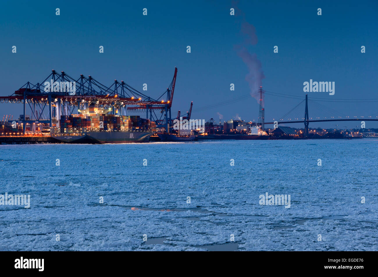 Containerschiff vor einer Containerbrücke im Winter, Altenwerder, Hamburg, Deutschland Stockfoto