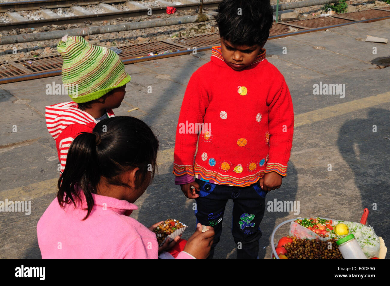 Drei junge indische Kinder frühstücken Streetfood Kichererbsen Bahnhof Delhi Indien Stockfoto