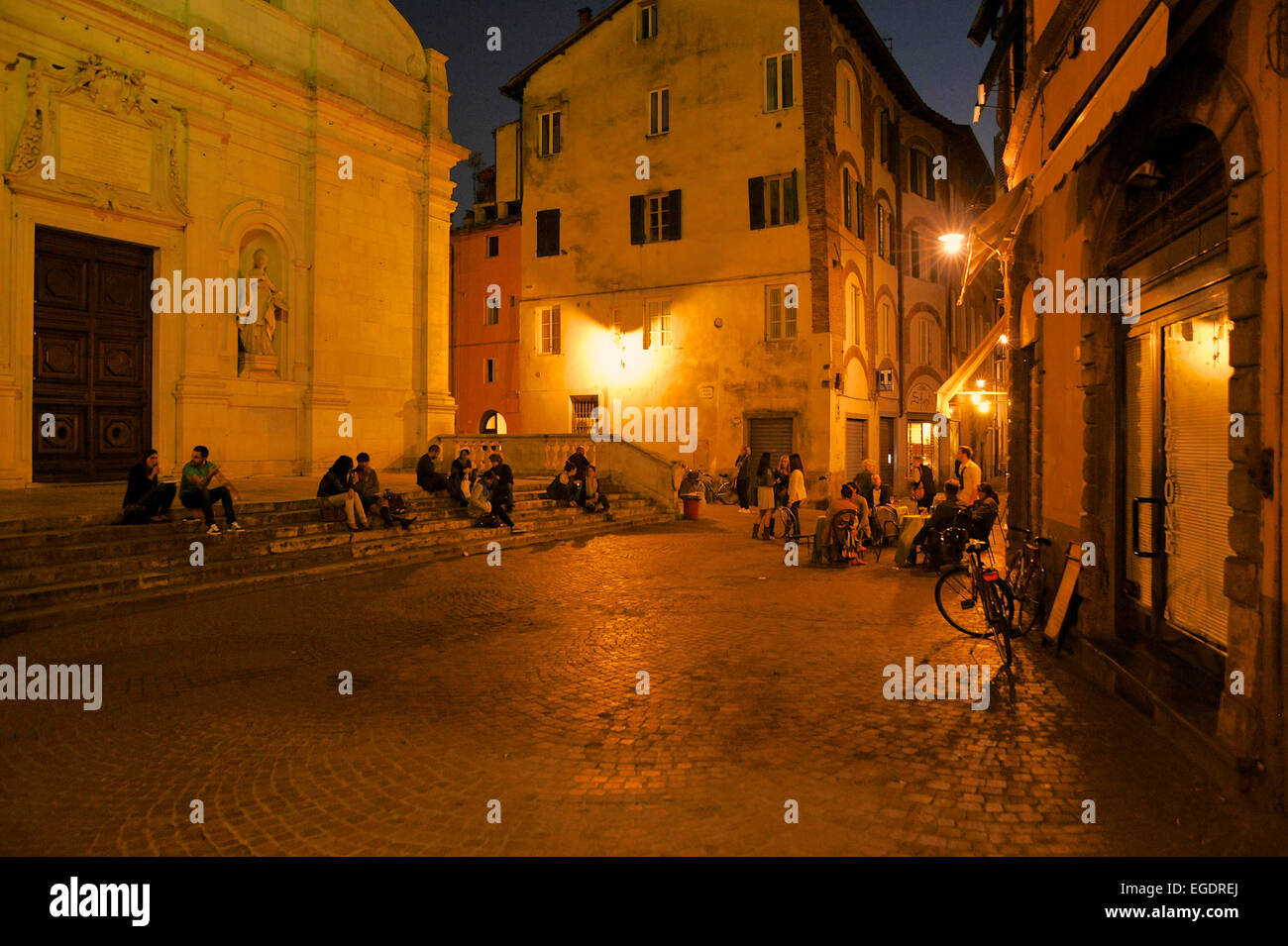 Menschen in der Altstadt am Abend und eine Bar mit Tischen im Freien am Abend, Lucca, Toskana, Italien Stockfoto