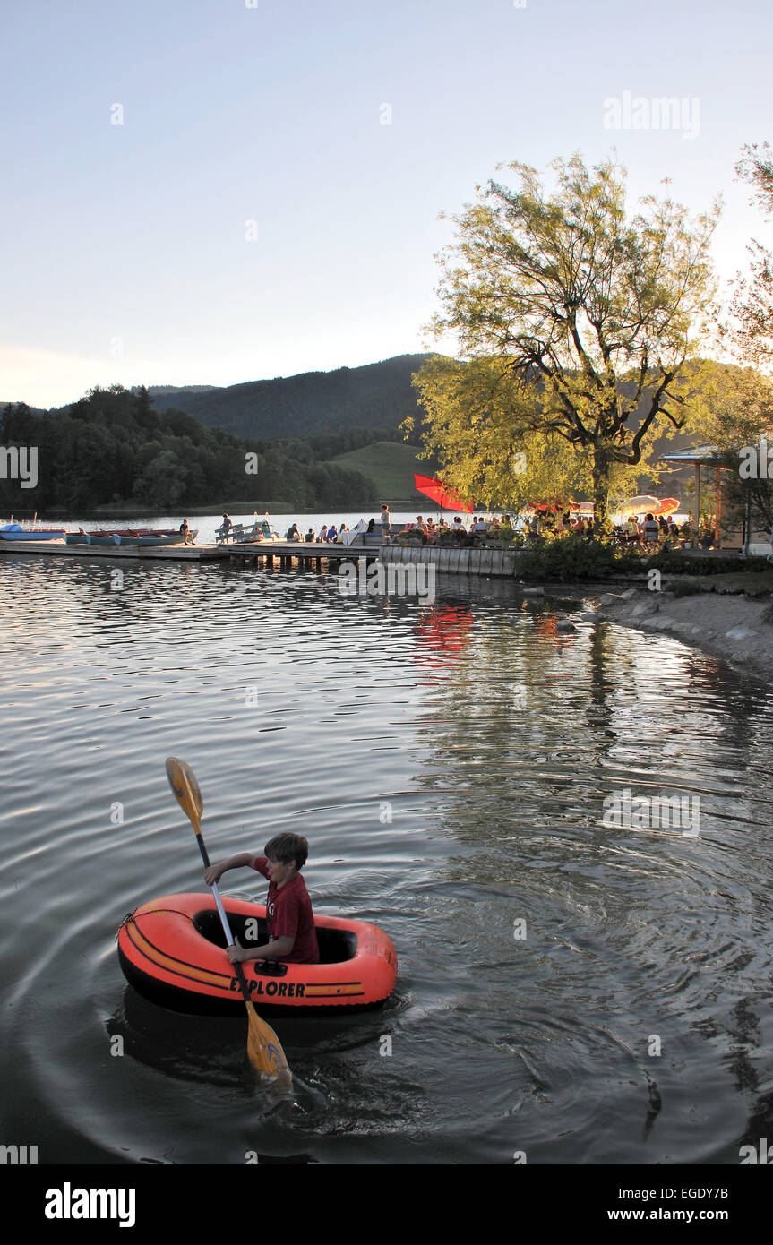 Junge in einem Paddelboot nahe dem Bootsverleih und Café in Schliersee, Schliersee See, Bayern, Deutschland Stockfoto