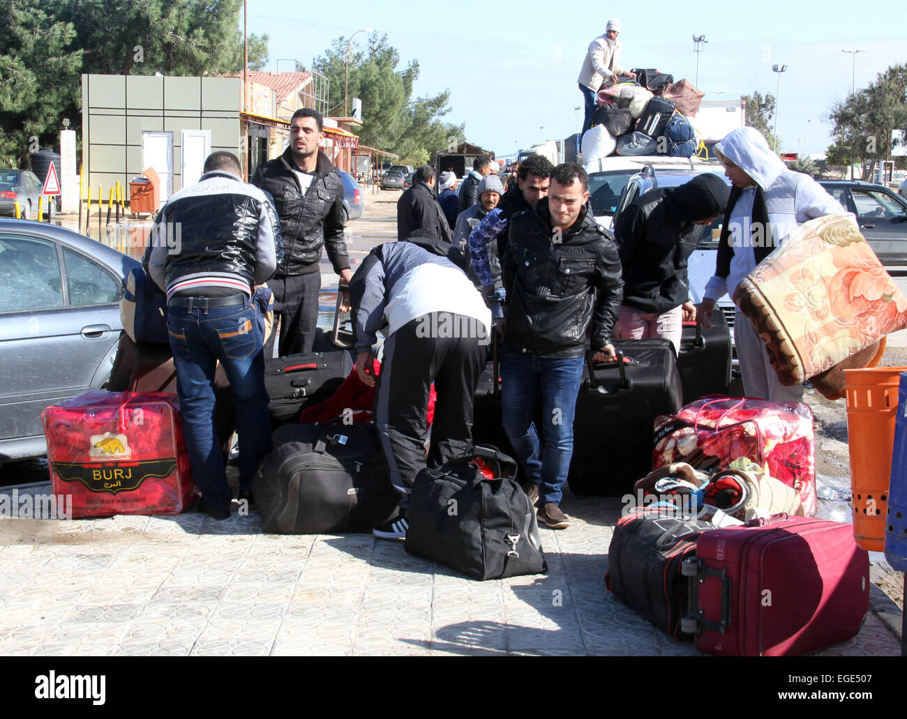 RAS Jadir, Libyen. 23. Februar 2015. Ägypter Entladen ihr Gepäck an der tunesisch-libyschen Grenze in Ras Jadir, Libyen, am 23. Februar 2015. Hunderte ägyptischer Arbeiter haben aus Libyen evakuiert worden, nach den islamischen Staat veröffentlicht das Video zeigt die Enthauptung von 21 ägyptischen koptischen Christen entführt. © Hamza Türkei/Xinhua/Alamy Live-Nachrichten Stockfoto
